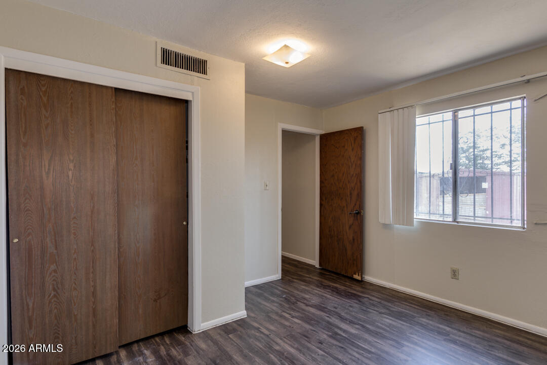 1301 West Indian School Road, Unit B Phoenix, AZ 85013 - Photo 5 of 9 a view of an empty room with wooden floor and a window