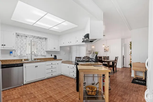 a kitchen with granite countertop white cabinets and white appliances