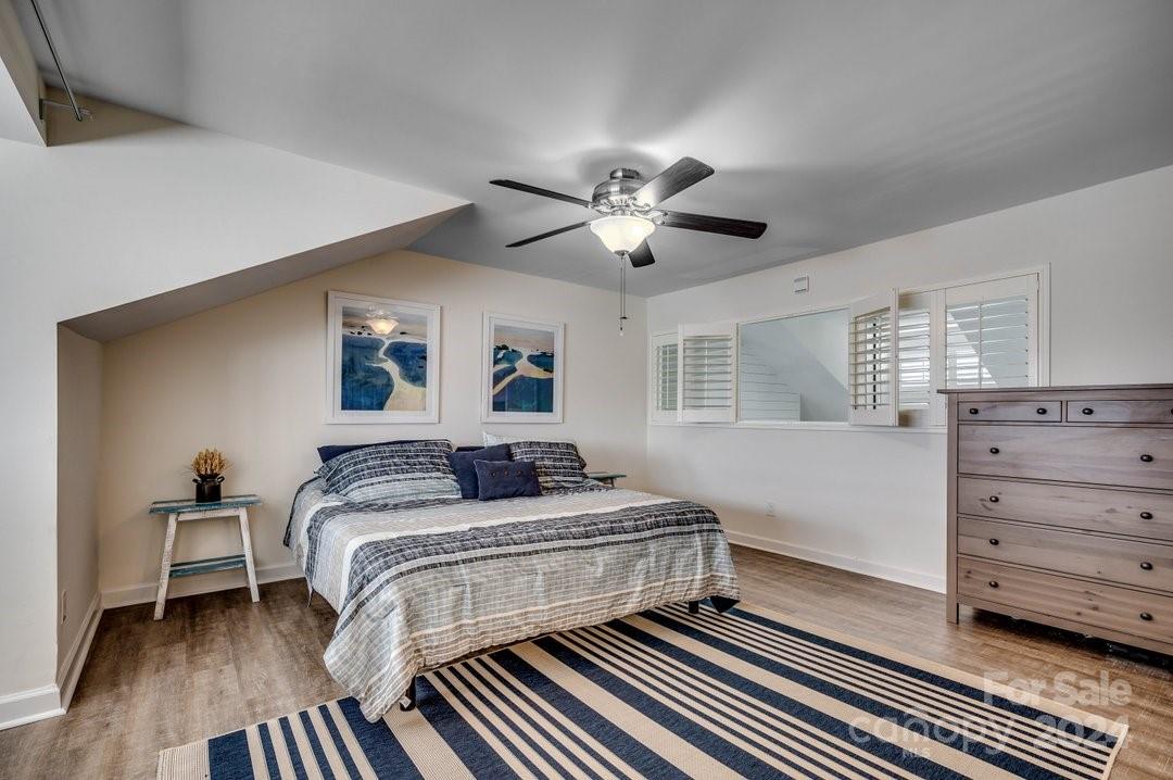 4396 Baldwin Avenue, Unit 40 Little River, SC 29566 - Photo 17 of 24 a bedroom with a bed and a chandelier