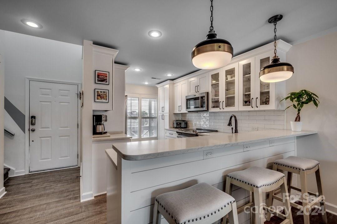 4396 Baldwin Avenue, Unit 40 Little River, SC 29566 - Photo 6 of 24 a kitchen with stainless steel appliances granite countertop a stove a sink and a chandelier