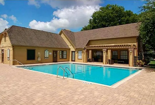 a view of an house with swimming pool and porch