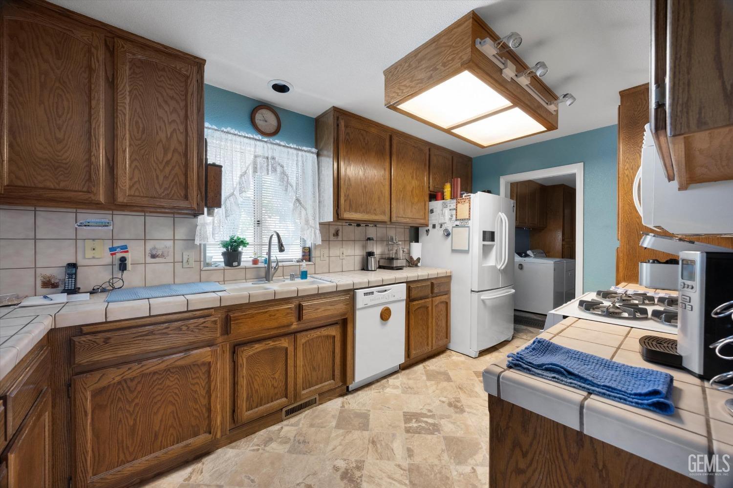 Undisclosed Address Tehachapi, CA 93561 - Photo 21 of 47 a kitchen with a sink stove and cabinets