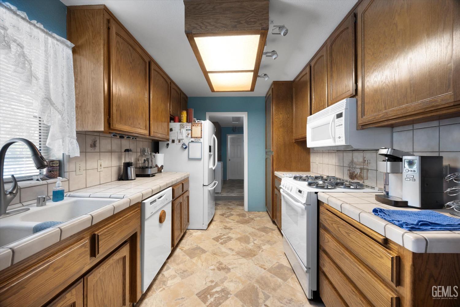 Undisclosed Address Tehachapi, CA 93561 - Photo 22 of 47 a kitchen with stainless steel appliances granite countertop a sink stove refrigerator and cabinets