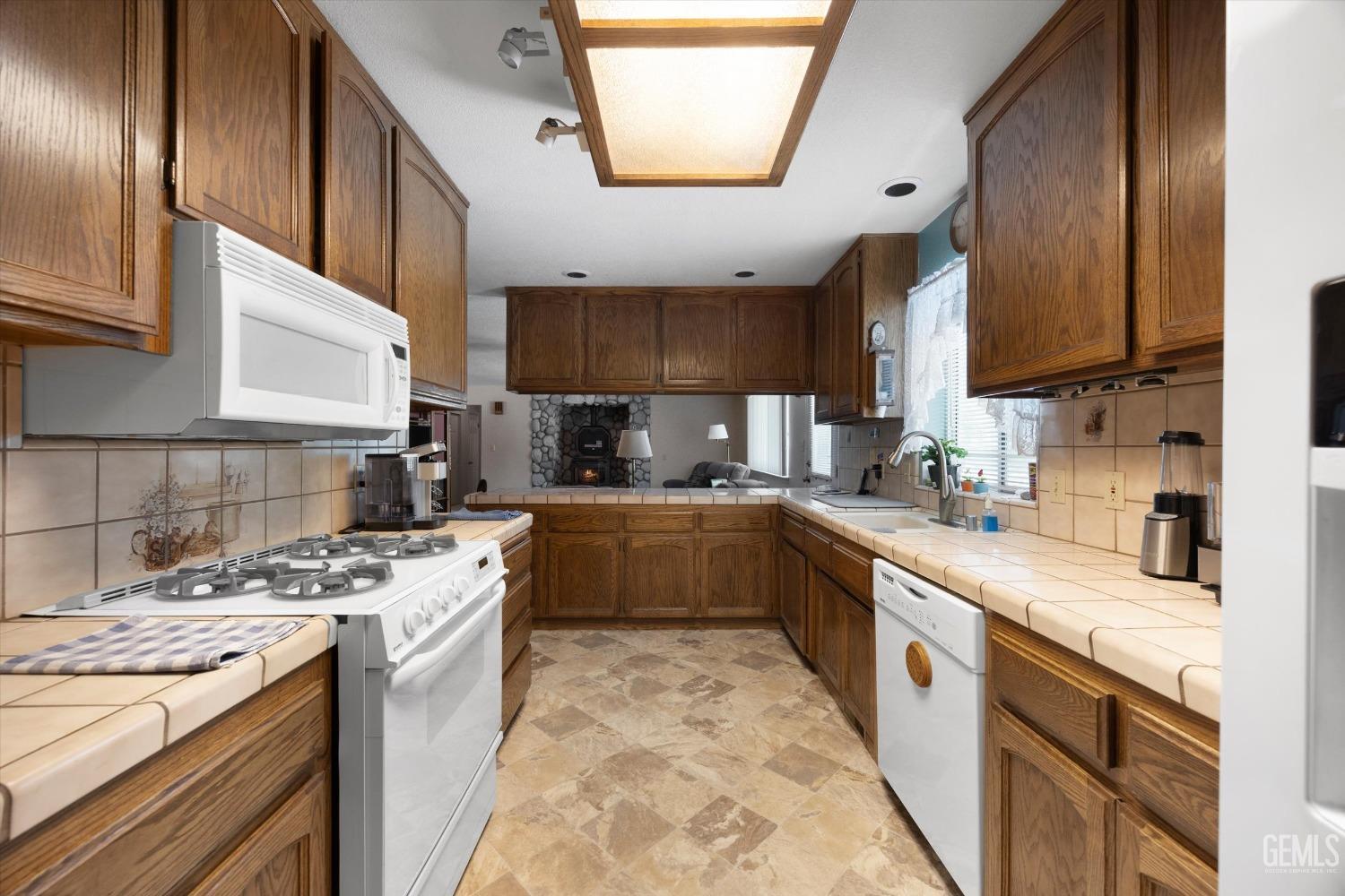 Undisclosed Address Tehachapi, CA 93561 - Photo 23 of 47 a large kitchen with stainless steel appliances granite countertop a stove a sink dishwasher and cabinets with wooden floor
