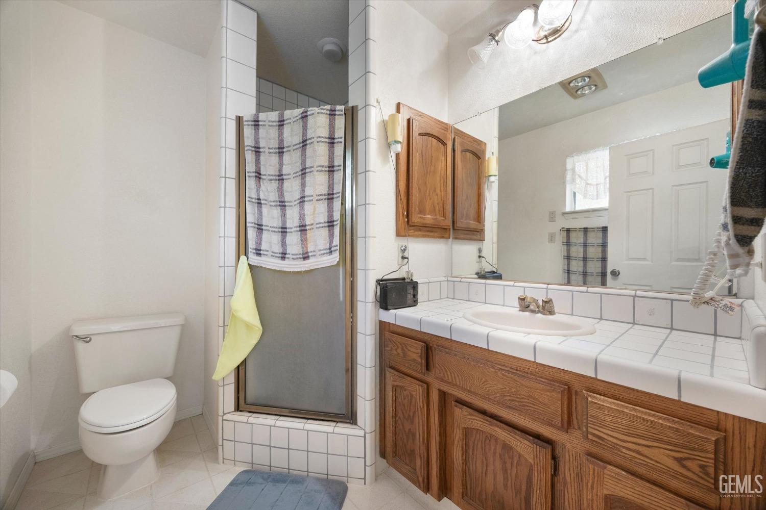 Undisclosed Address Tehachapi, CA 93561 - Photo 26 of 47 a bathroom with a granite countertop toilet sink and mirror