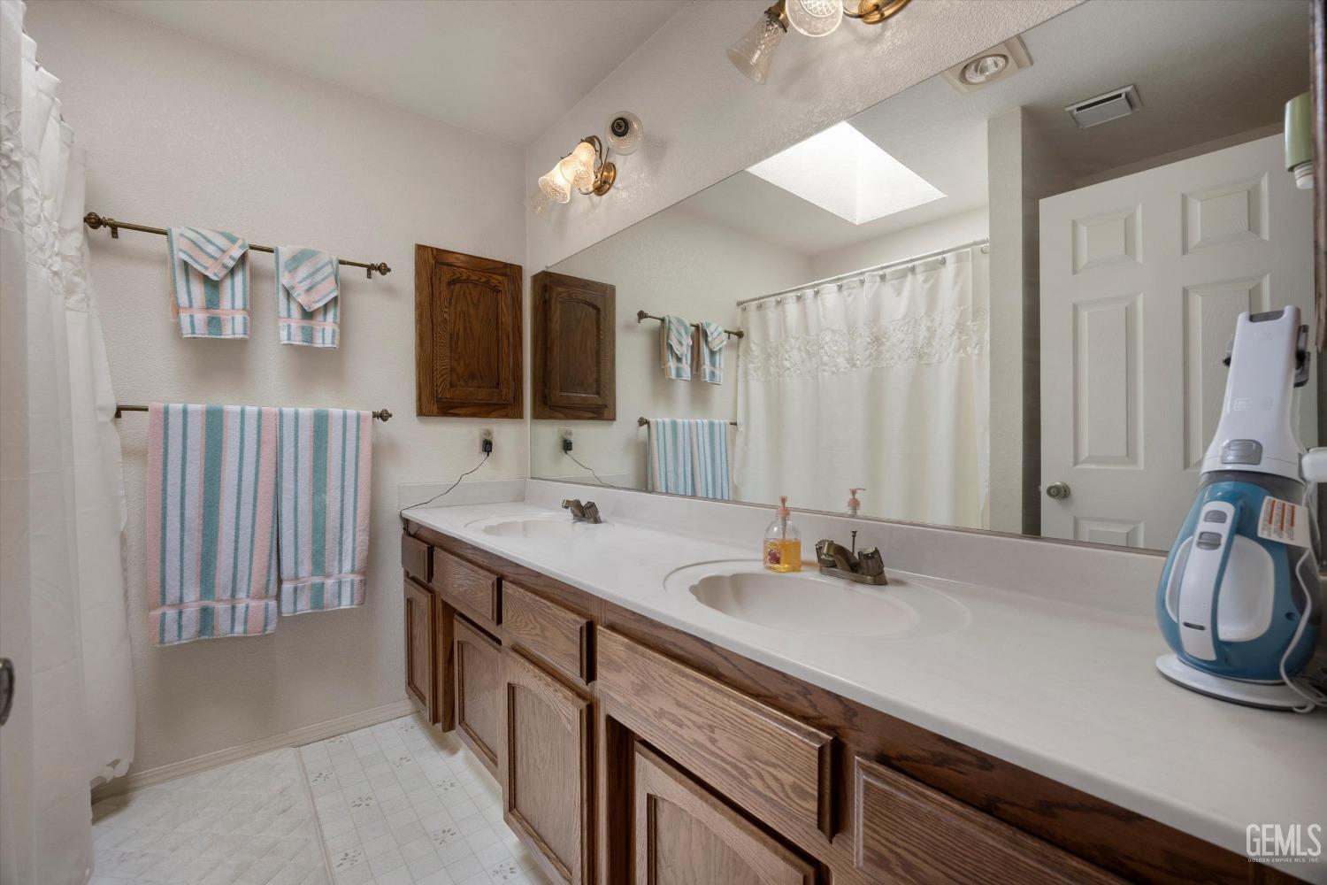 Undisclosed Address Tehachapi, CA 93561 - Photo 29 of 47 a bathroom with a double vanity sink and a mirror