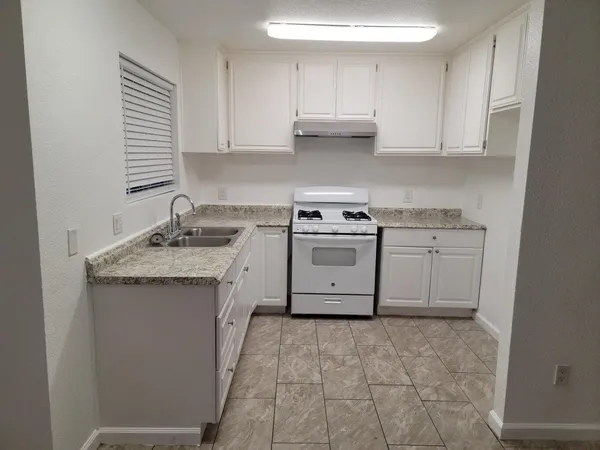 a kitchen with a sink stove and cabinets
