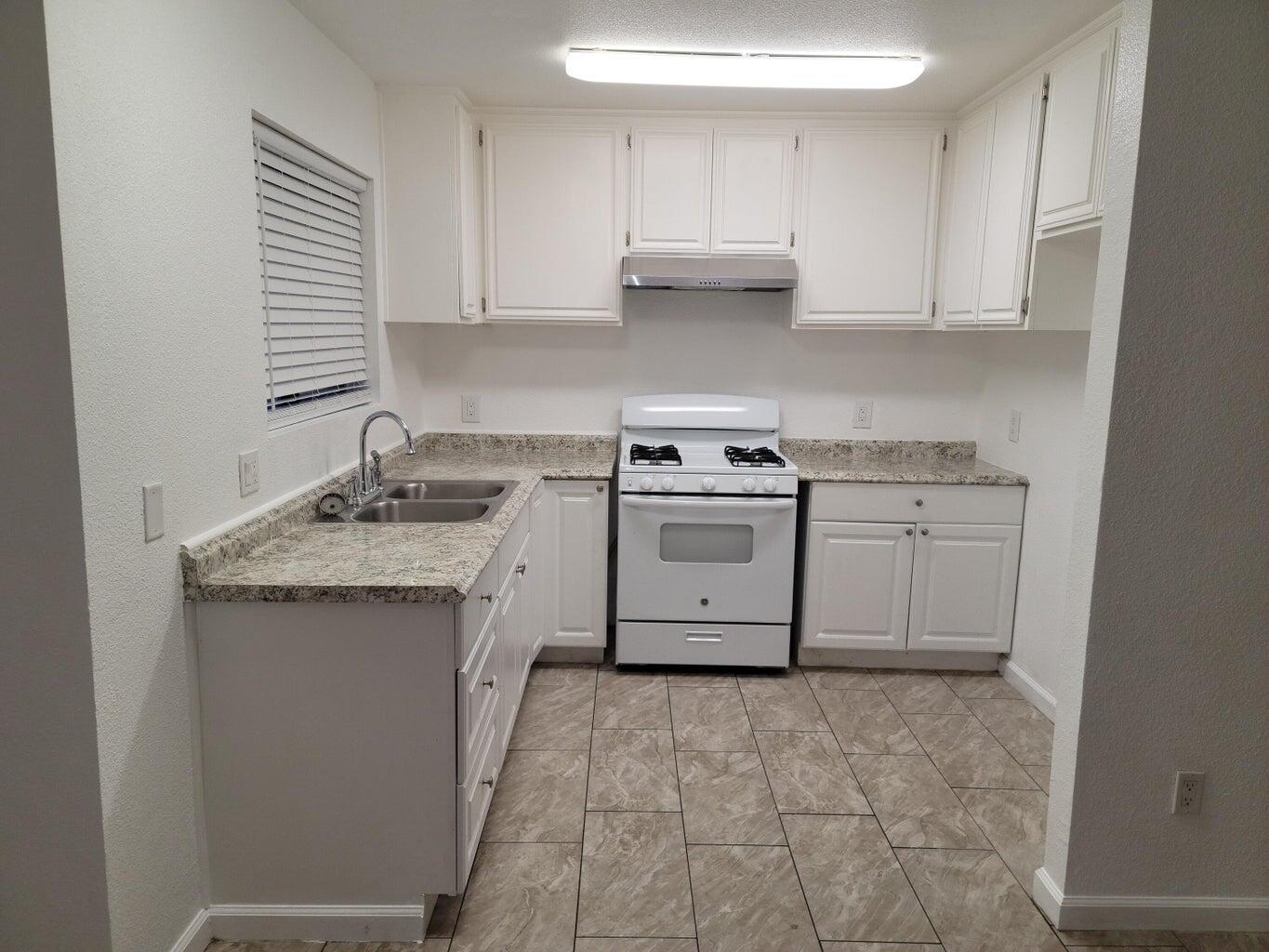 43965 Towne Street Indio, CA 92201 - Photo 12 of 31 a kitchen with a sink stove and cabinets