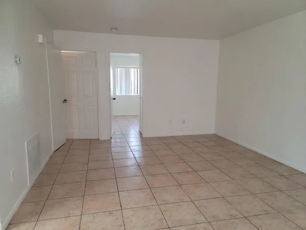 a view of a livingroom with an empty space and a window