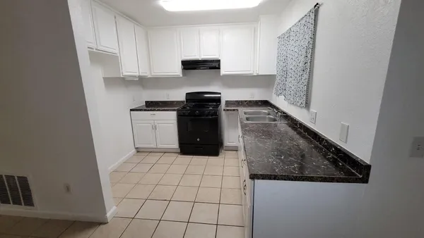 a kitchen with a stove top oven and cabinets