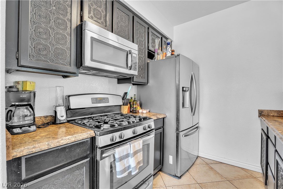 1409 Sycamore Spring Court Las Vegas, NV 89128 - Photo 12 of 28 This functional kitchen features stainless steel appliances and ample counter space for daily living.