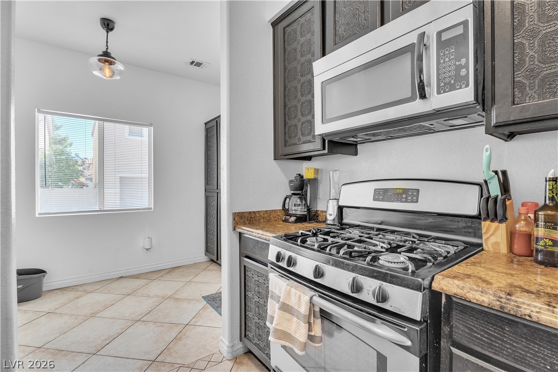 1409 Sycamore Spring Court Las Vegas, NV 89128 - Photo 13 of 28 This modern kitchen features a gas range, microwave, and ample counter space for all your culinary needs.