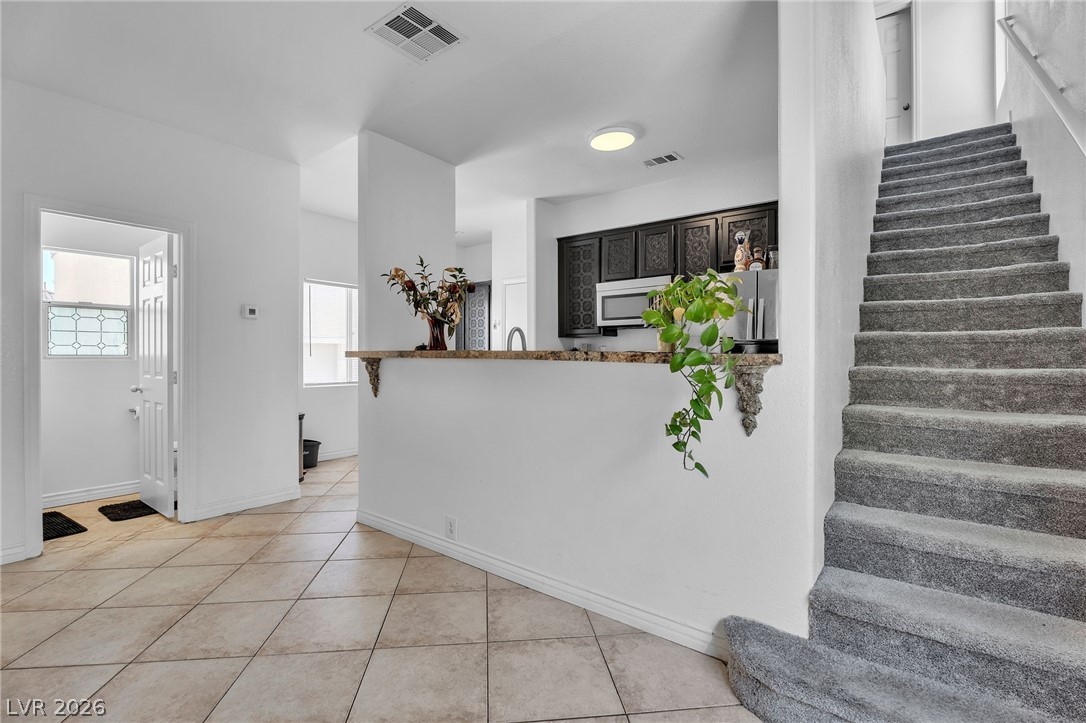 1409 Sycamore Spring Court Las Vegas, NV 89128 - Photo 14 of 28 This inviting interior features a functional kitchen and convenient staircase access to the upper level.