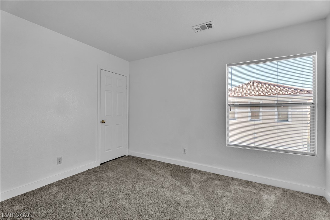 1409 Sycamore Spring Court Las Vegas, NV 89128 - Photo 17 of 28 This spacious bedroom offers ample natural light and plush carpeting for comfort.