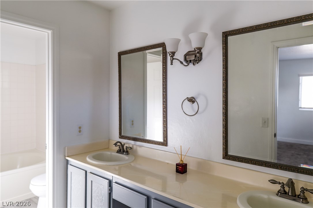 1409 Sycamore Spring Court Las Vegas, NV 89128 - Photo 18 of 28 This bright bathroom features a spacious double vanity with ample counter space and individual mirrors.