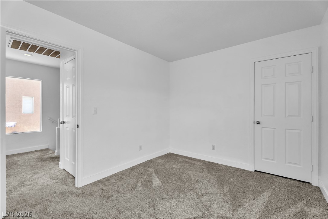 1409 Sycamore Spring Court Las Vegas, NV 89128 - Photo 19 of 28 This bright and airy room features soft carpeting and ample natural light, creating a comfortable living space.