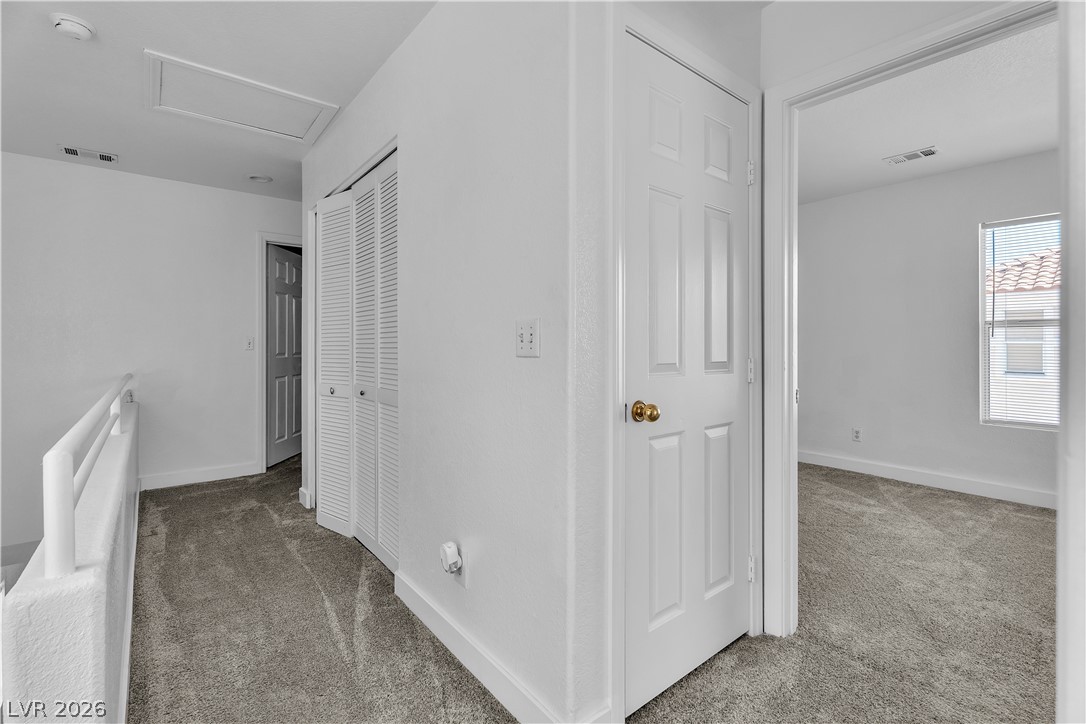 1409 Sycamore Spring Court Las Vegas, NV 89128 - Photo 21 of 28 This interior hallway features comfortable carpeted flooring and an accessible attic entrance.