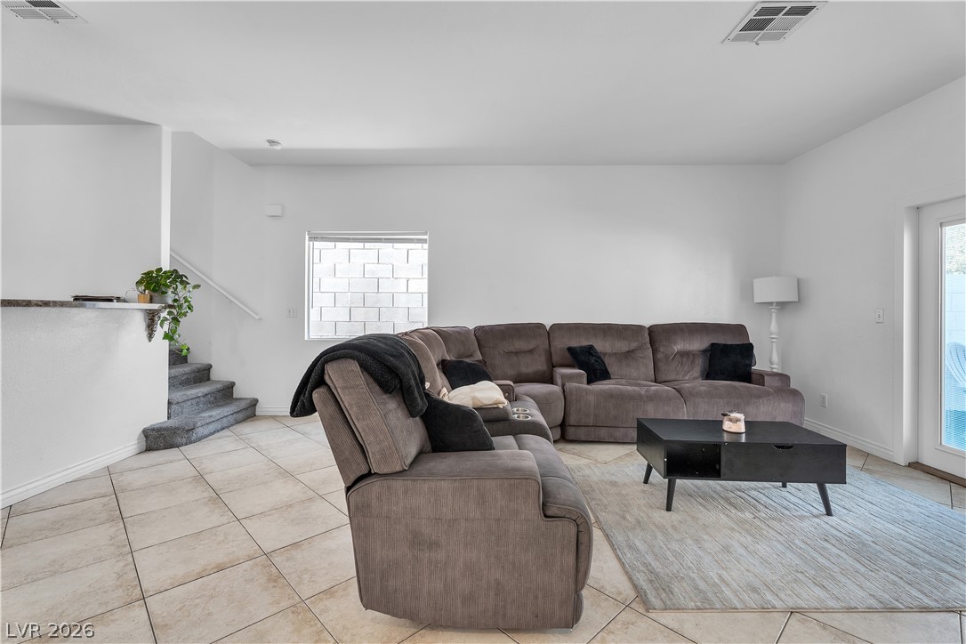 1409 Sycamore Spring Court Las Vegas, NV 89128 - Photo 4 of 28 Bright and open living area with inviting tile flooring and convenient staircase access.