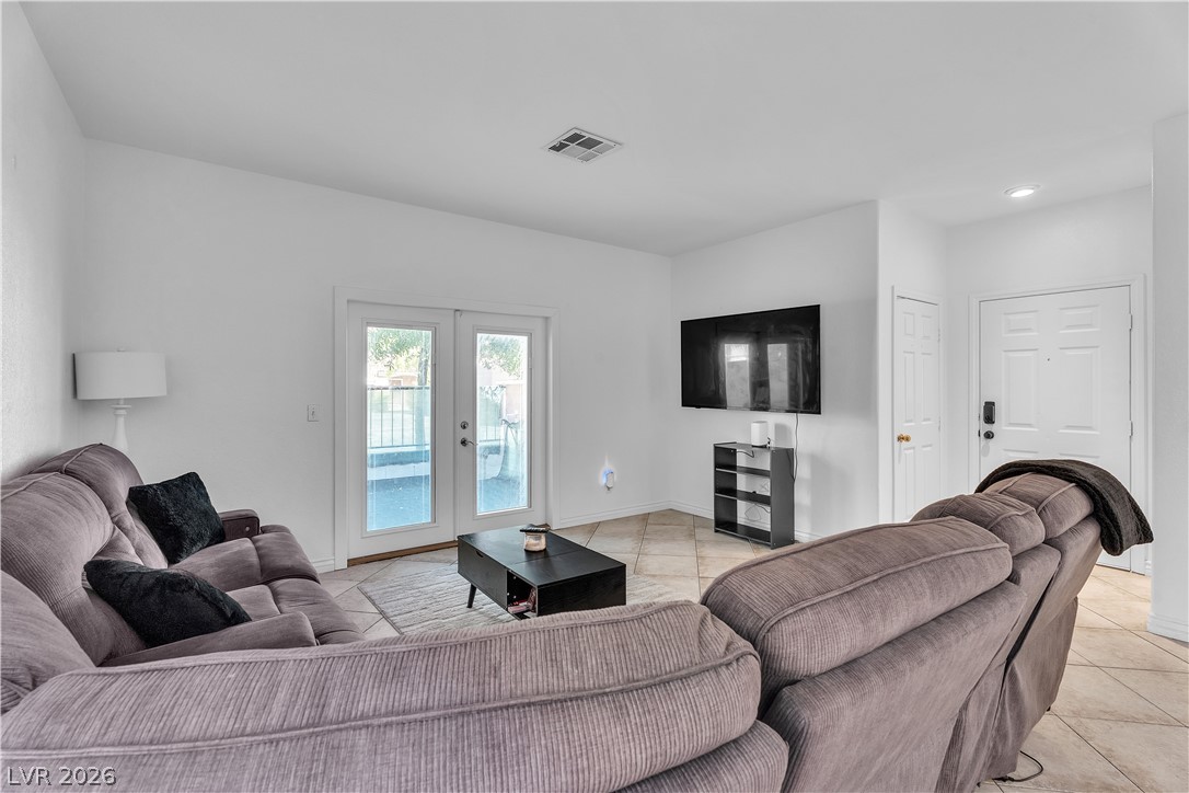 1409 Sycamore Spring Court Las Vegas, NV 89128 - Photo 6 of 28 This bright living room offers direct outdoor access through elegant French doors, perfect for comfortable daily living.