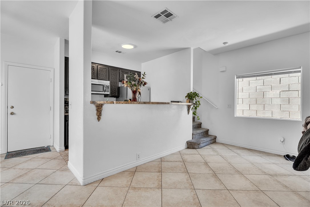 1409 Sycamore Spring Court Las Vegas, NV 89128 - Photo 10 of 28 This living area features a kitchen pass-through and a stairway, ideal for comfortable daily living.