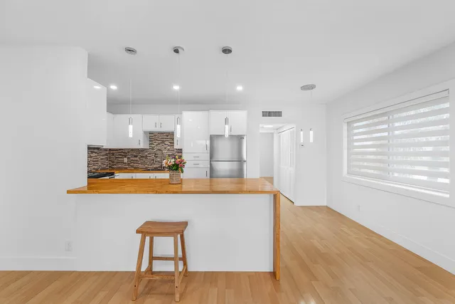 a large white kitchen with a large window