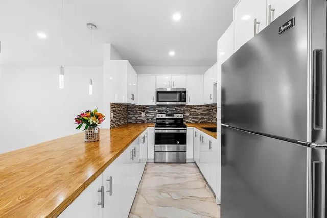 a large kitchen with cabinets and stainless steel appliances