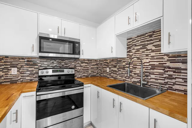 a kitchen with granite countertop cabinets stainless steel appliances and a counter space