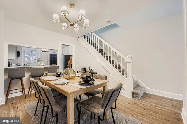 a view of a dining room with furniture a chandelier and wooden floor