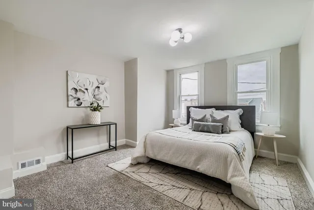 a bedroom with a bed and painting on the wall