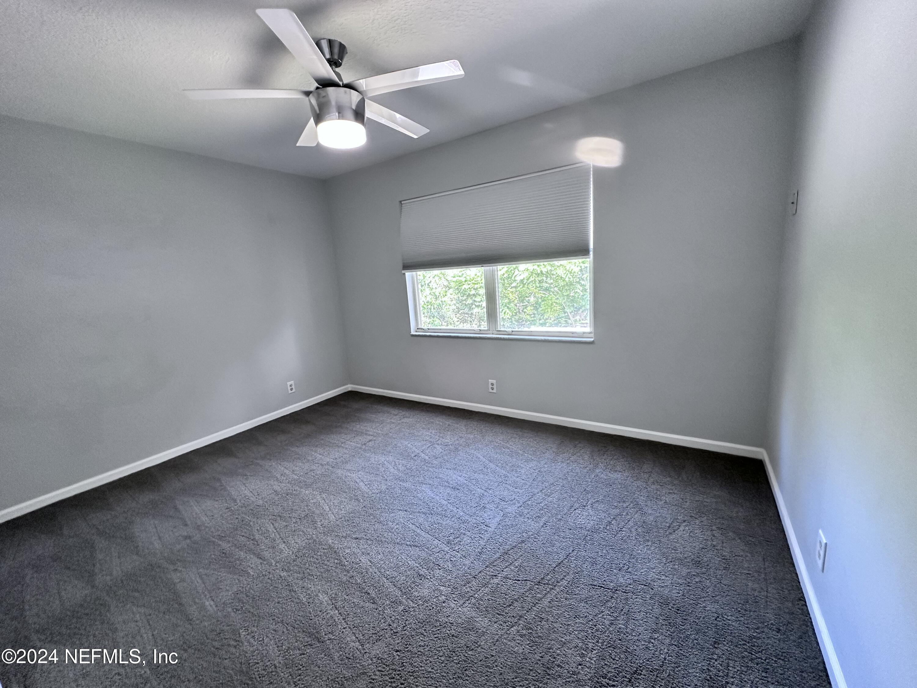 4521 Trevi Drive Jacksonville, FL 32257 - Photo 21 of 24 an empty room with windows and ceiling fan