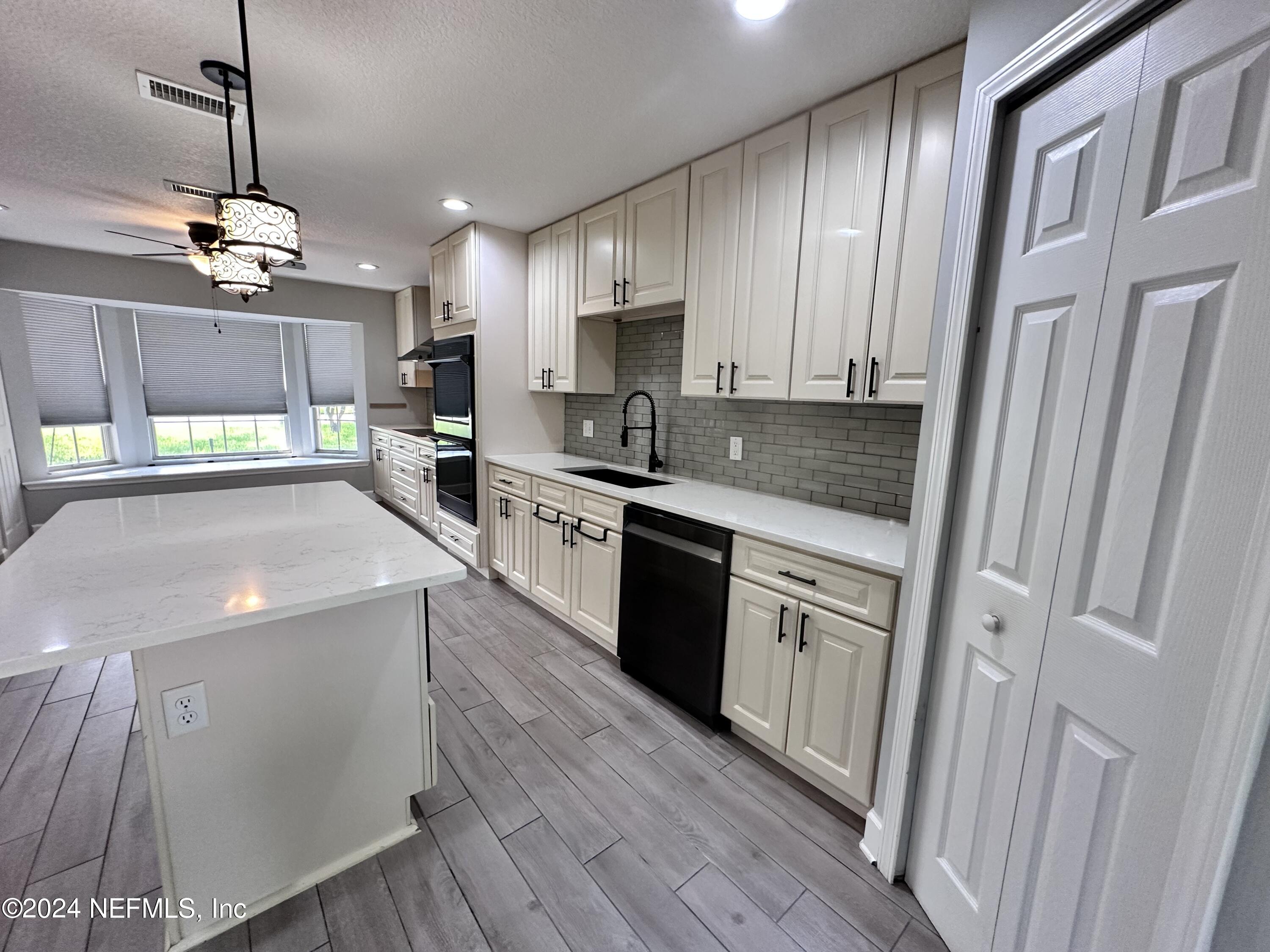 4521 Trevi Drive Jacksonville, FL 32257 - Photo 3 of 24 a kitchen with stainless steel appliances a sink a stove a refrigerator cabinets and wooden floor