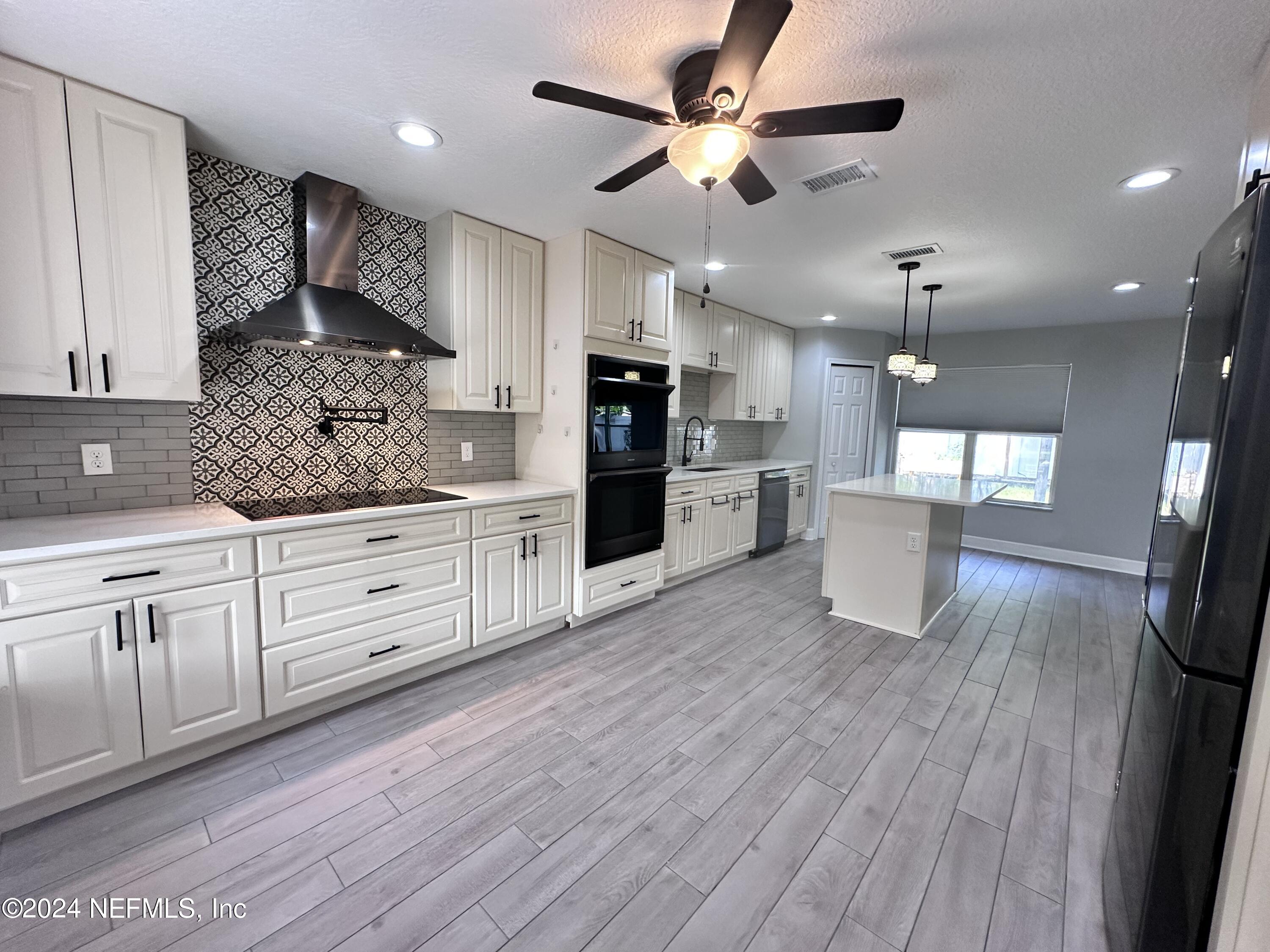 4521 Trevi Drive Jacksonville, FL 32257 - Photo 4 of 24 a large kitchen with cabinets wooden floor and stainless steel appliances