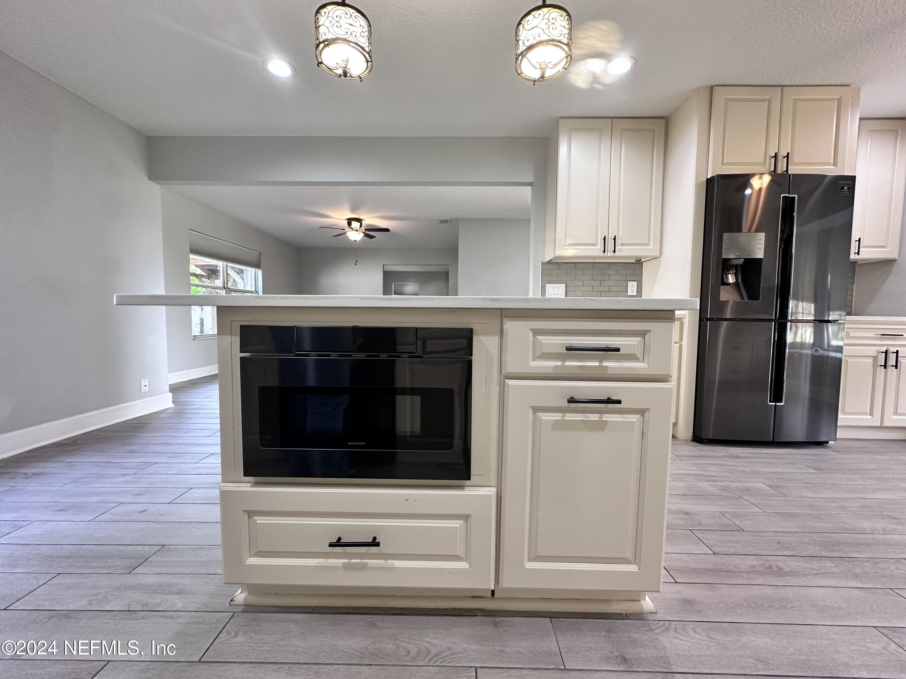 4521 Trevi Drive Jacksonville, FL 32257 - Photo 7 of 24 a kitchen with a refrigerator and a stove top oven