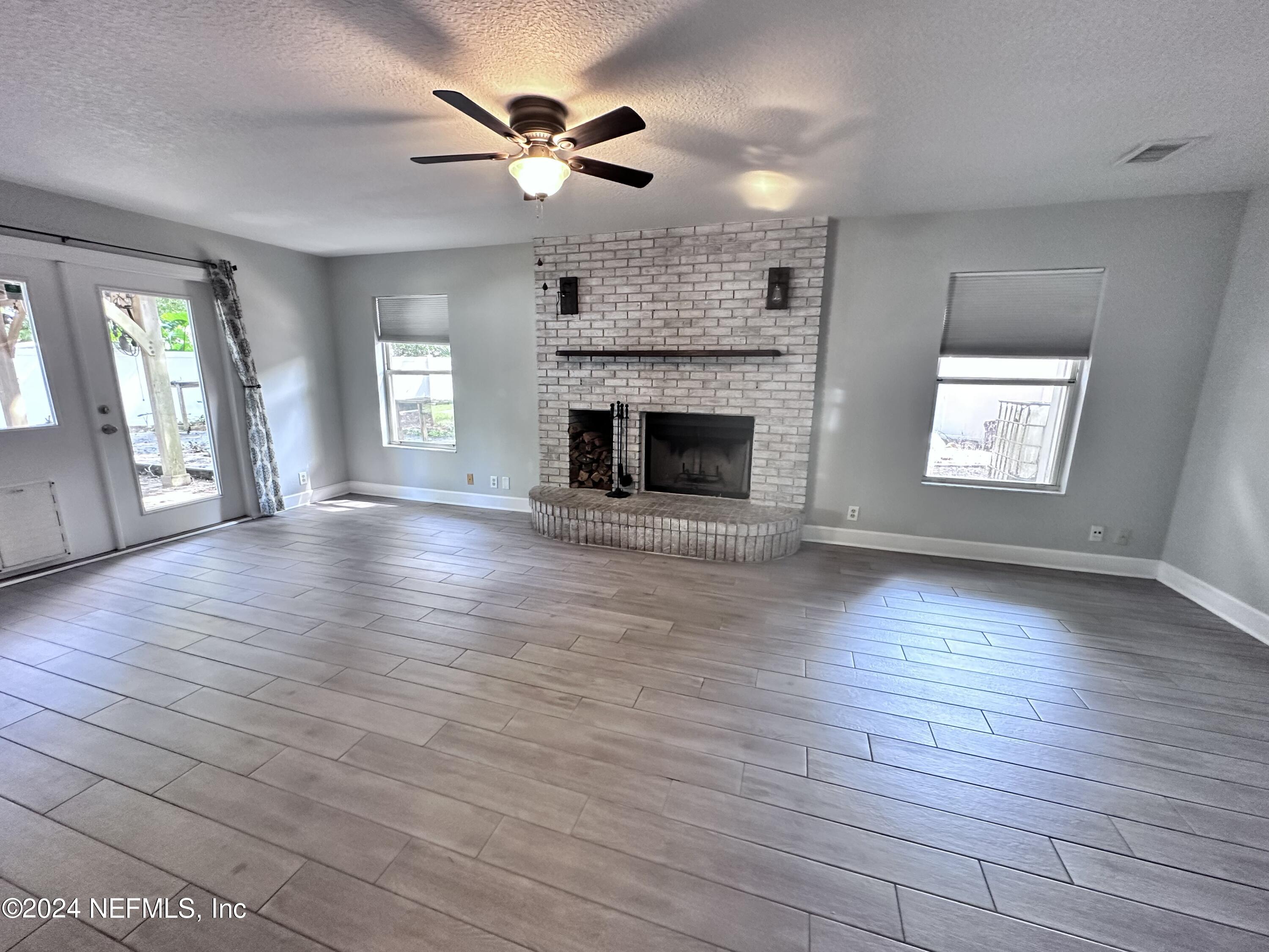 4521 Trevi Drive Jacksonville, FL 32257 - Photo 8 of 24 an empty room with wooden floor fireplace and windows
