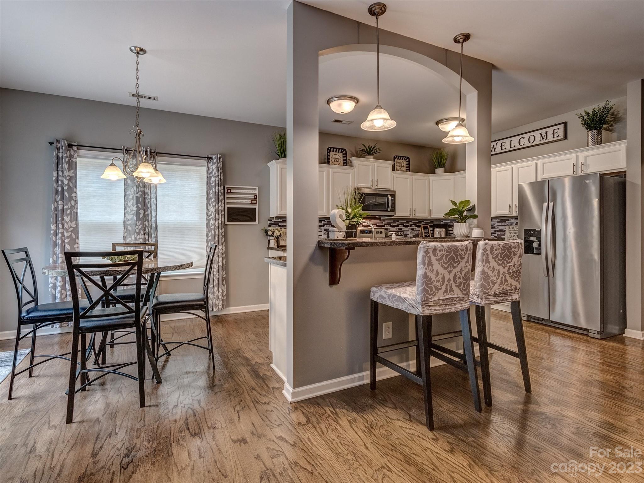 1051 Duckwood Road Lancaster, SC 29720 - Photo 6 of 18 a kitchen with stainless steel appliances a dining table chairs refrigerator and microwave