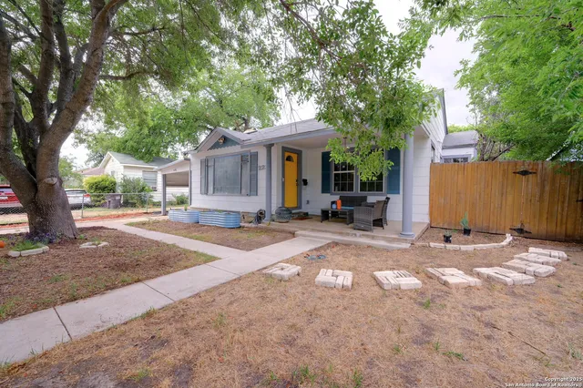 a view of a house with backyard and a tree