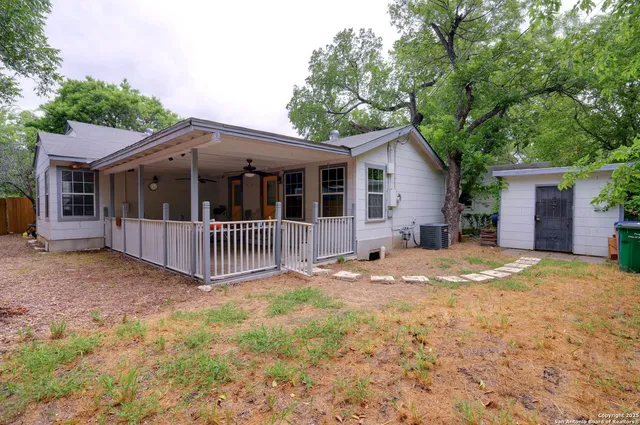 a view of a house with a yard and large tree