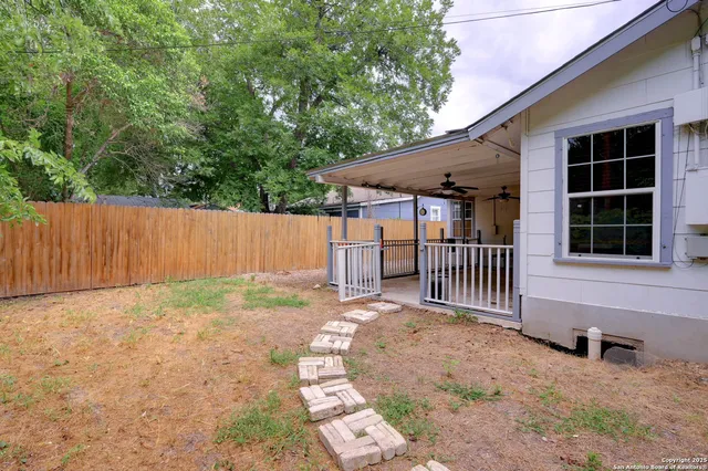 a view of a house with a yard and wooden fence