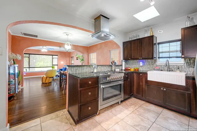 a kitchen with stainless steel appliances granite countertop a stove refrigerator and cabinets