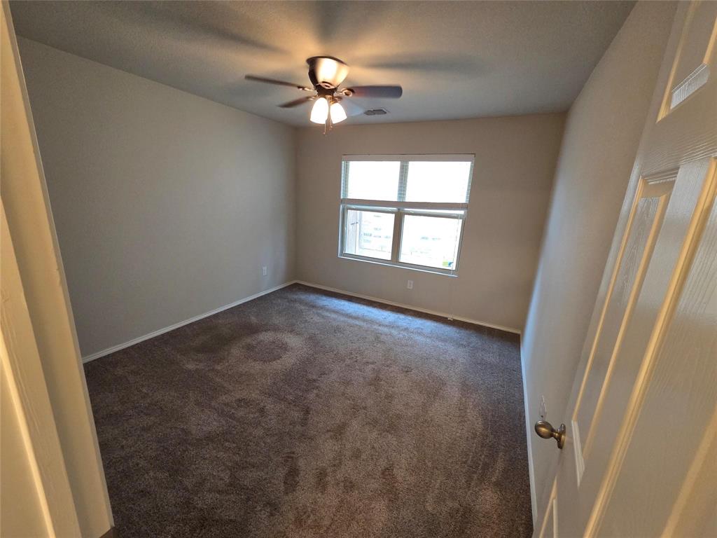 7504 Boat Wind Road Fort Worth, TX 76179 - Photo 16 of 17 an empty room with windows and fan