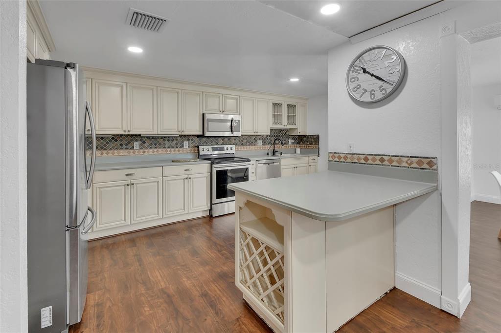 115 Juan Road DeBary, FL 32713 - Photo 12 of 41 a kitchen with a sink a stove cabinets and wooden floor