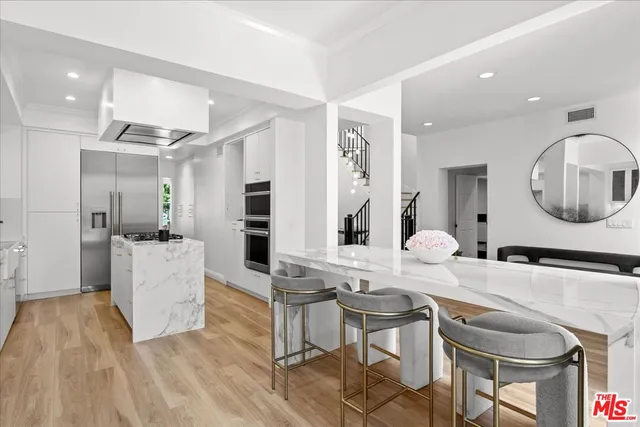 a room with a table chairs and a kitchen view