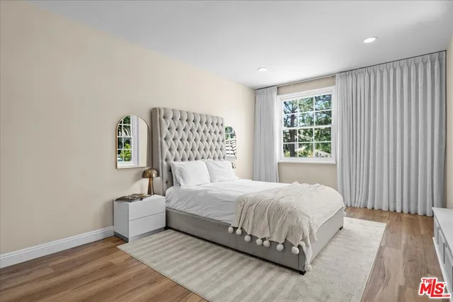 a bedroom with a bed and a large window