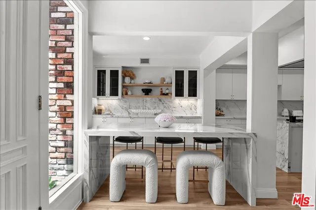 a kitchen with cabinets and chairs