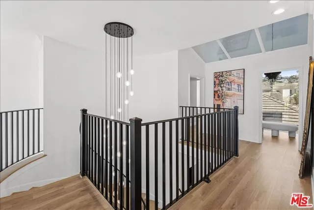 a view of a hallway with wooden floor and stairs