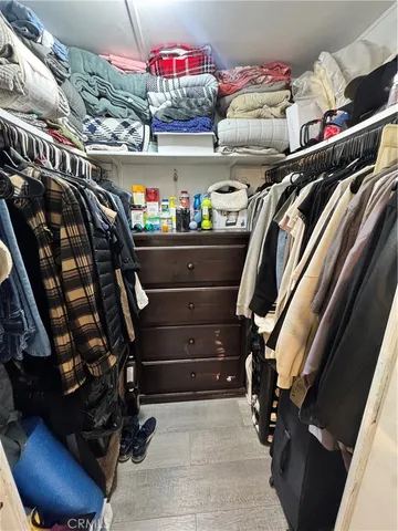 a view of walk in closet with clothes and shoes
