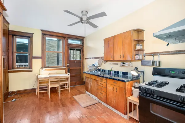 a dining room with a window wooden floor and stainless steel appliances