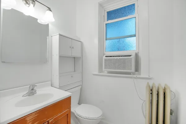 a bathroom with a sink vanity mirror and toilet