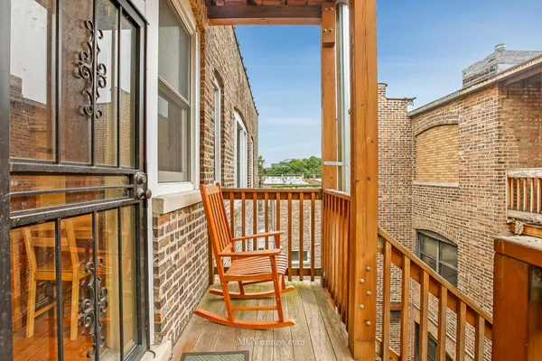 a view of a balcony with furniture and floor to ceiling window