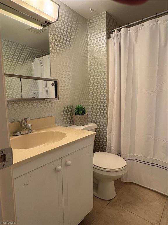315 St Andrews Boulevard, Unit A2 Naples, FL 34113 - Photo 16 of 17 Full bathroom with vanity, a shower with shower curtain, and light tile patterned floors